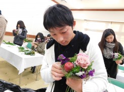 スイートピーを花束に入れる学生