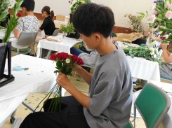 花束を座って制作する学生