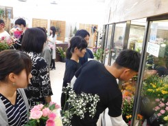 店の冷蔵庫から花を選ぶ学生ら