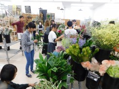 店頭に並ぶ花を選ぶ学生ら