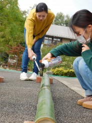 竹を焼く学生