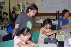 生涯学習講座を受講する小学生に多肉植物の寄せ植えを指導する学生