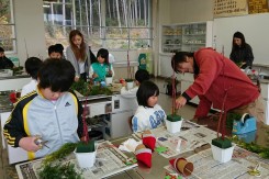 クリスマスフラワーアレンジメントを小学生に指導する学生の様子