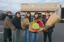 生花市場で購入した花材を抱える学生ら