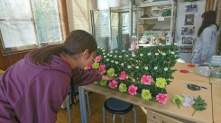発表会に向けて生花祭壇制作の練習する学生