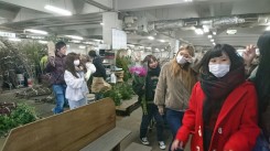 生花市場で購入した花材を抱える学生ら