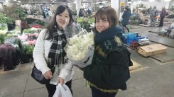 生花市場で購入した花材を抱える学生ら