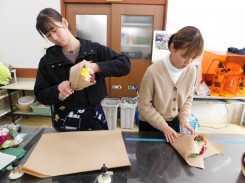 花束をラッピングする学生