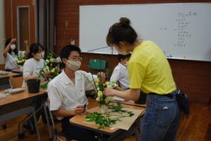 オープンキャンパスに参加した方々にアレンジメントの指導をする学生