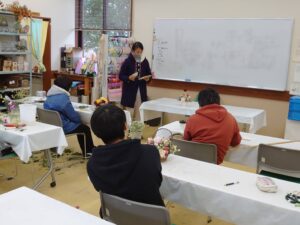 制作したアレンジメントを発表する学生と評価する先生