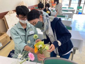 花束制作している高校生をサポートする学生