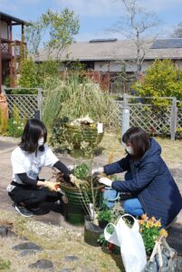 寄せ植え制作のアシスタントをする学生