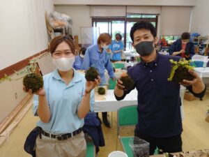 完成した苔玉を手にする学生ら