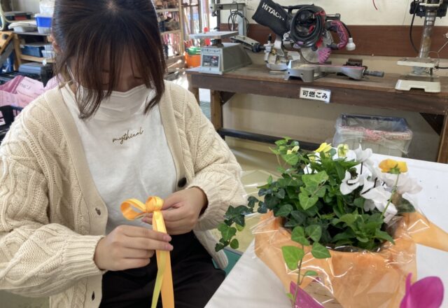 寄せかごに付けるリボンを制作する学生
