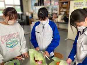 花束を制作する高校生のサポートをする学生