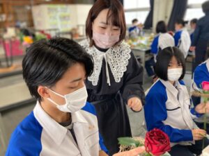花束を制作する高校生のサポートをする学生