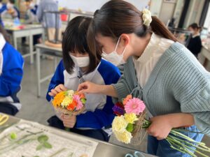 花束を制作する高校生のサポートをする学生