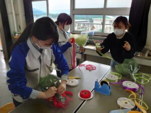 花束を制作する高校生のサポートをする学生