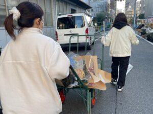 卸売市場で切り花を運ぶ学生ら