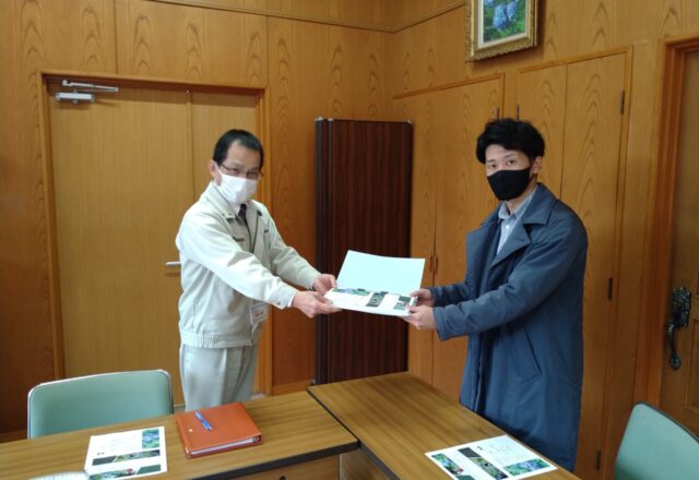 卒業論文を手渡しする学生