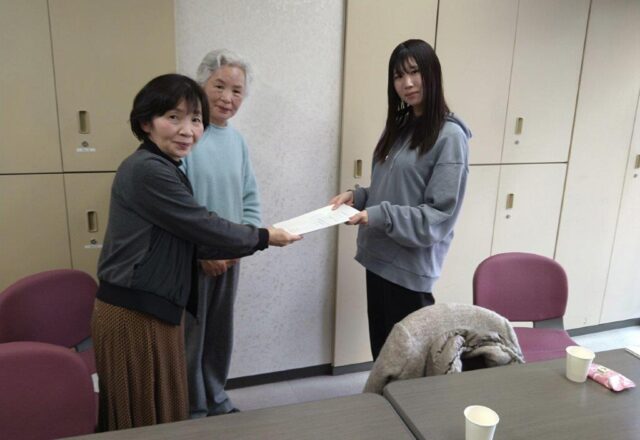 卒業論文を手渡しする学生